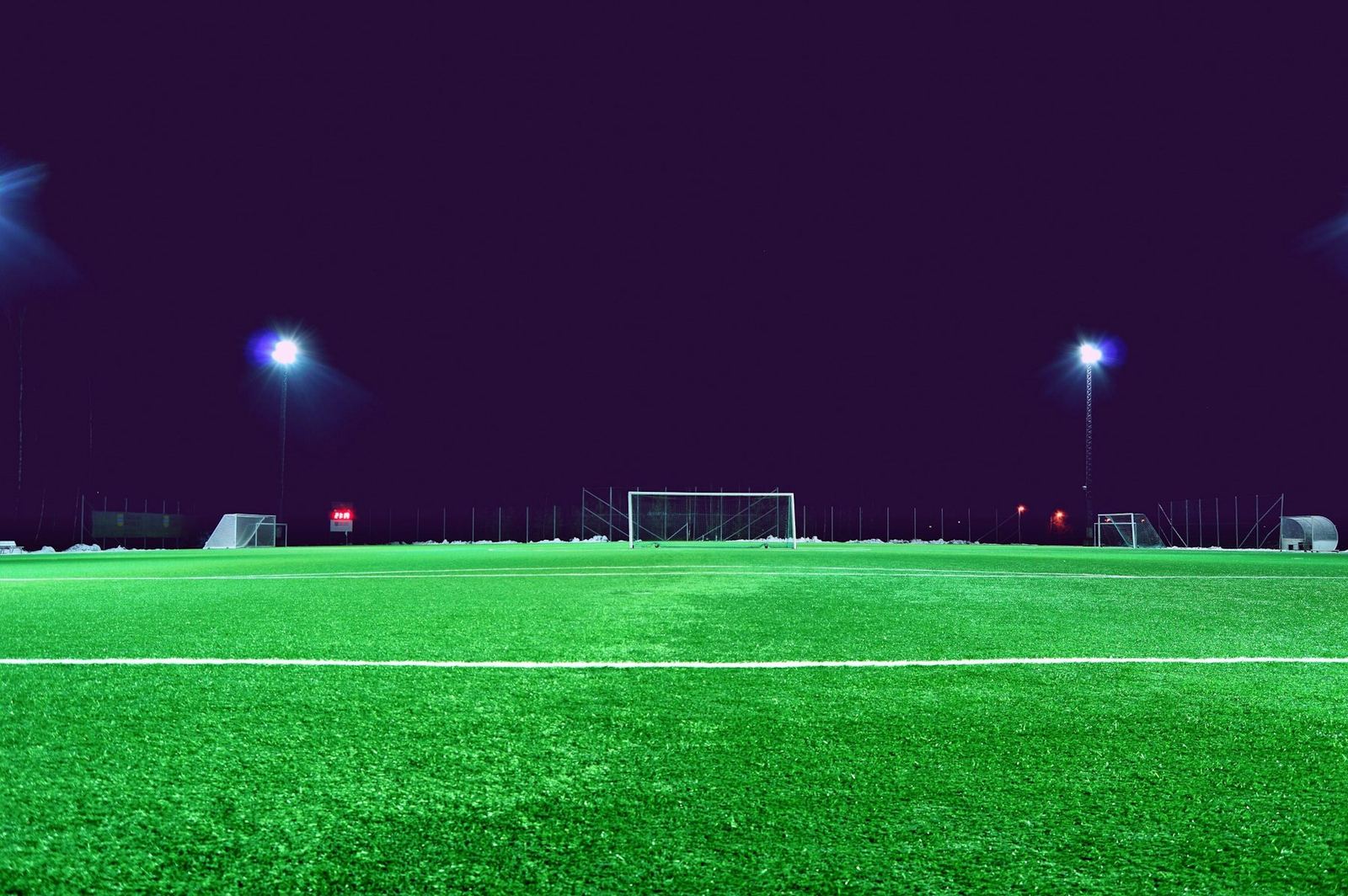 Campo de entrenamiento iluminado por reflectores en la noche